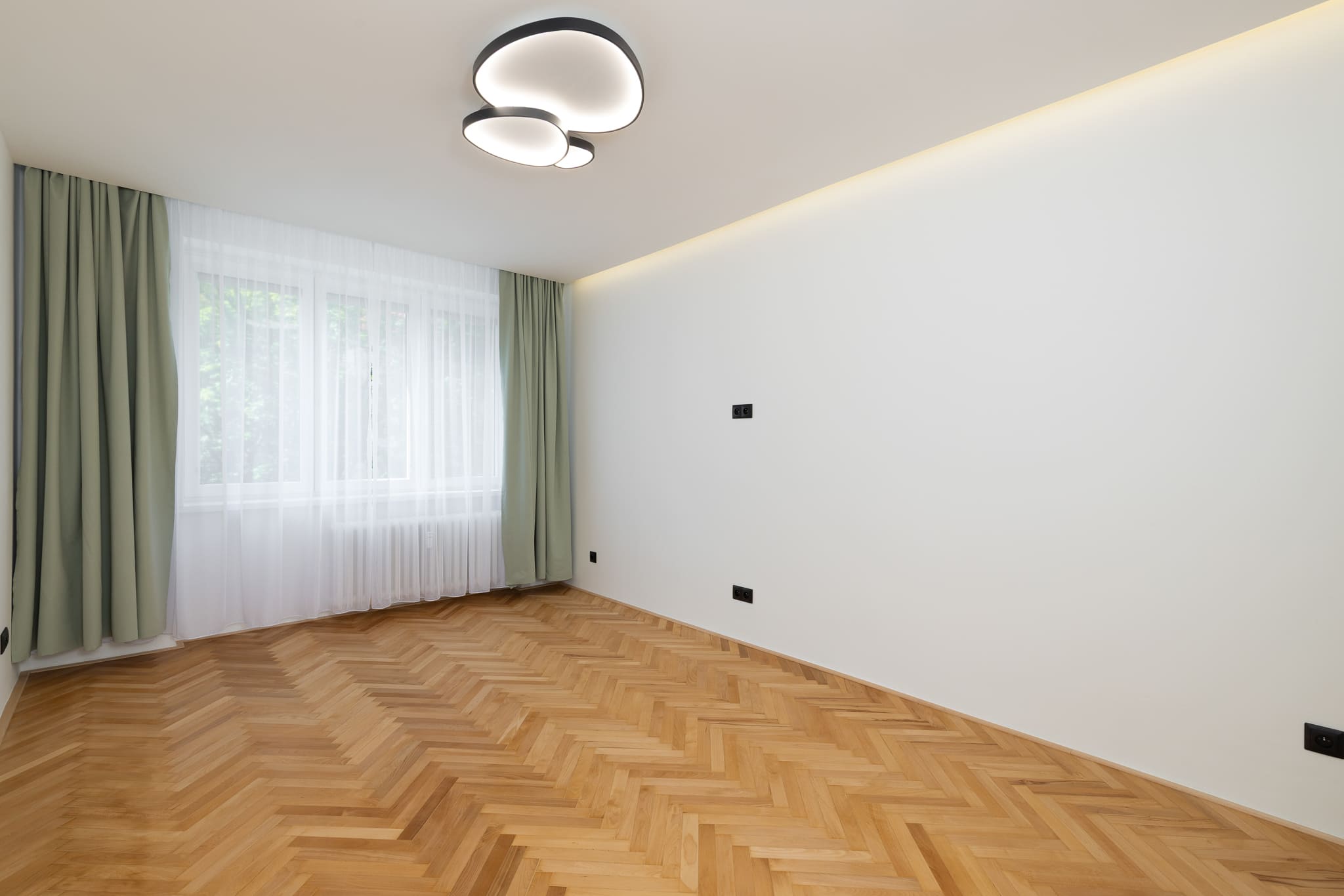 Ložnice s renovovanými parketami a šalvějovými závěsy